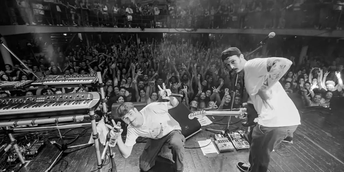 Circo Voador 2026 | BRAZA Transforma a Lapa em Baile Solar e Prova que Utopia Tem Ritmo Fotografia em preto e branco com ponto de vista de trás do palco com grupo Braza em apresentação no Circo Voador.