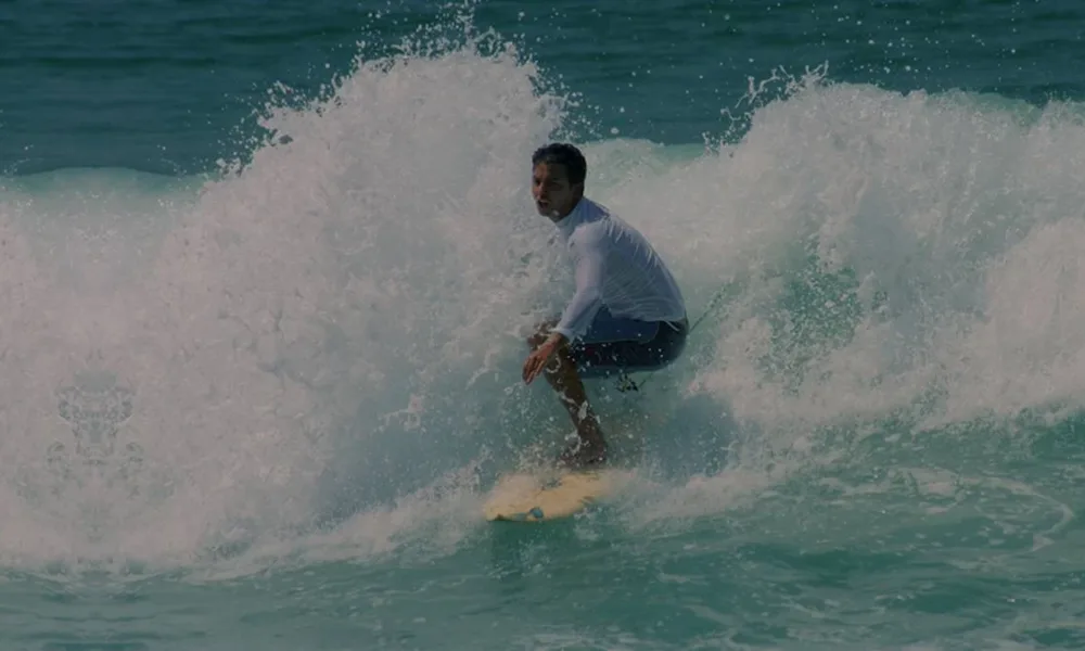 Guido Schäffer surfando no mar. Imagem do site oficial.