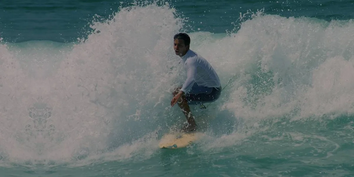 Guido Schäffer surfando no mar. Imagem do site oficial.