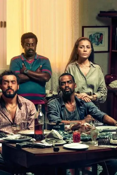 Personagens da série "Impuros", dos Disney+, reunidos em torno de mesa. Caracterização e ambientação de casa no estilo dos anos 90.