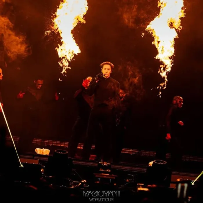 Jackson Wang em apresentação na Magic Man II World Tour, 2026. Cantor está no palco e há efeitos de pirotecnia à sua esquerda e direita.