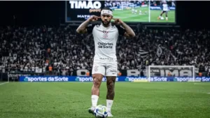 Memphis Depay com o uniforme do Corinthians, dedos levados ao ouvido, durante partida. Imagem gerada por IA.