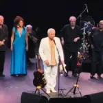 Paulinho da Viola, imagem horizontal, em palco no Qualistage 2026 ao lado de outros artistas..