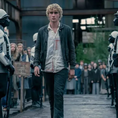 Joseph Zada como Haymitch Abernathy, protagonista do segundo filme spin-off de Jogos Vorazes: "Amanhecer na Colheita". Jovem anda entre guardas e adolescentes são separados por fila por idade na seleção de tributos.