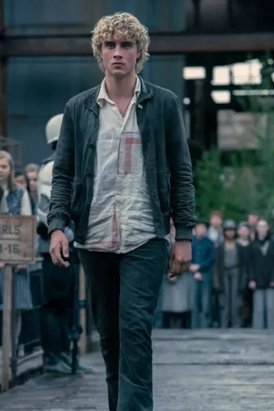 Joseph Zada como Haymitch Abernathy, protagonista do segundo filme spin-off de Jogos Vorazes: "Amanhecer na Colheita". Jovem anda entre guardas e adolescentes são separados por fila por idade na seleção de tributos.