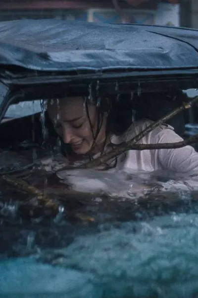 Phoebe Dynevor como Lisa Fields em "Ataque Brutal". Personagem está ensopada dentro de carro, um galho enorme entrando dentro do carro, e ela desesperada.