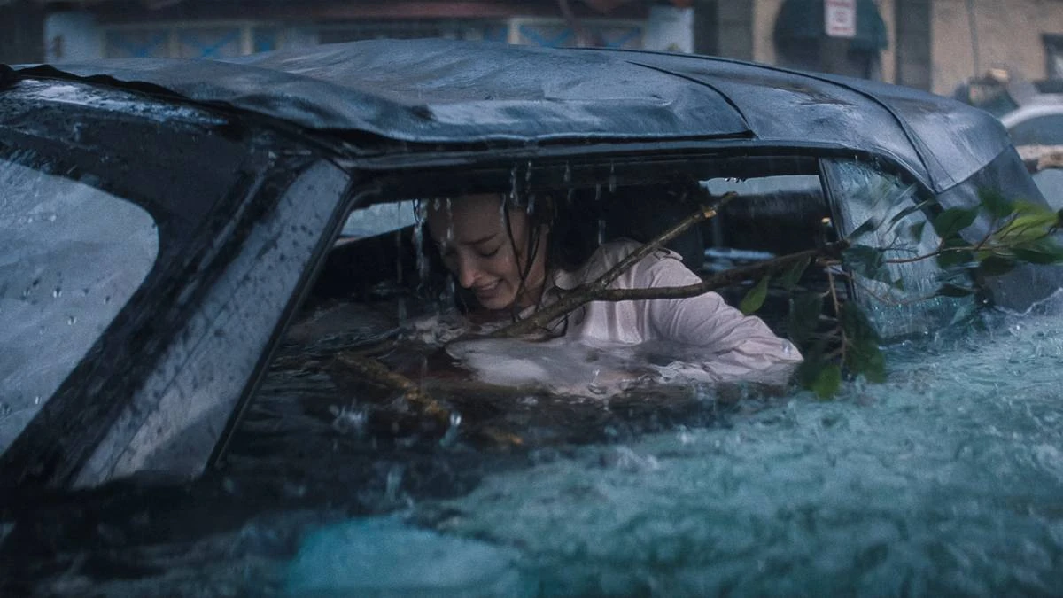 Ataque Brutal | Um Desastre Envolvente Que se Perde no Próprio Absurdo 2 Phoebe Dynevor como Lisa Fields em "Ataque Brutal". Personagem está ensopada dentro de carro, um galho enorme entrando dentro do carro, e ela desesperada.