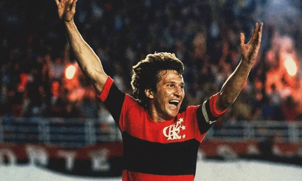 Crop do pôster do filme documentário "Zico: Samurai do Quintino", da Globo Filmes. Jogador está em partida comemorando gol com braços erguidos.