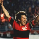 Crop do pôster do filme documentário "Zico: Samurai do Quintino", da Globo Filmes. Jogador está em partida comemorando gol com braços erguidos.