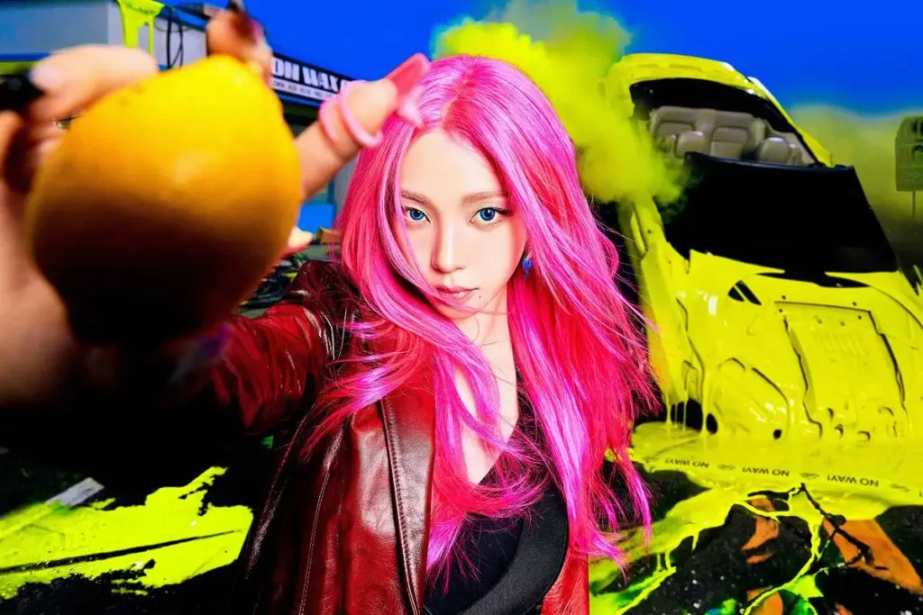 Esta imagem mostra Karina, do grupo aespa, em uma foto conceito para o álbum "LEMONADE", destacando seu cabelo rosa vibrante.