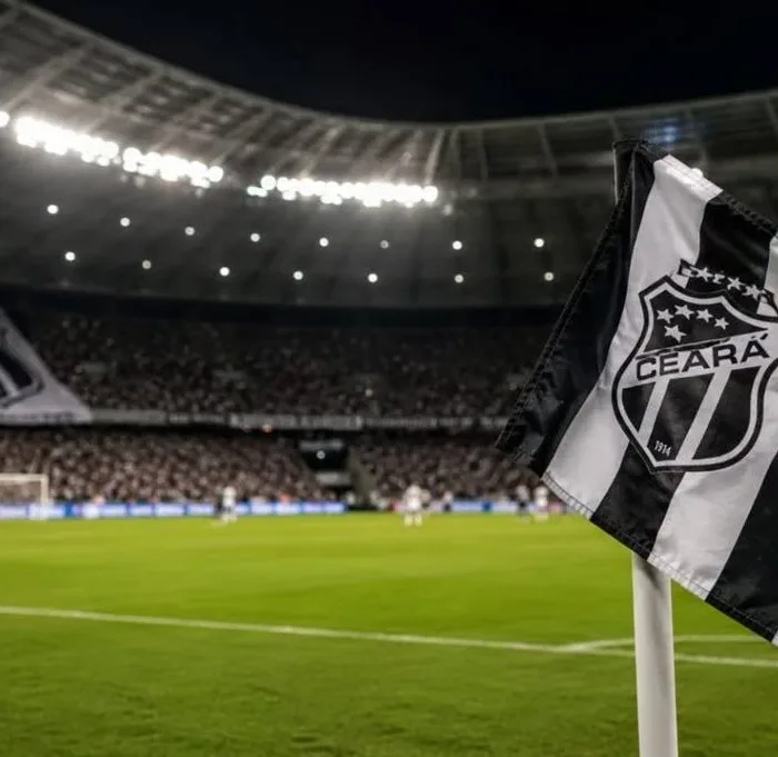 Bandeira do Ceará em riste em campo de futebol de noite durante partida, em destaque. Imagem gerada por IA.