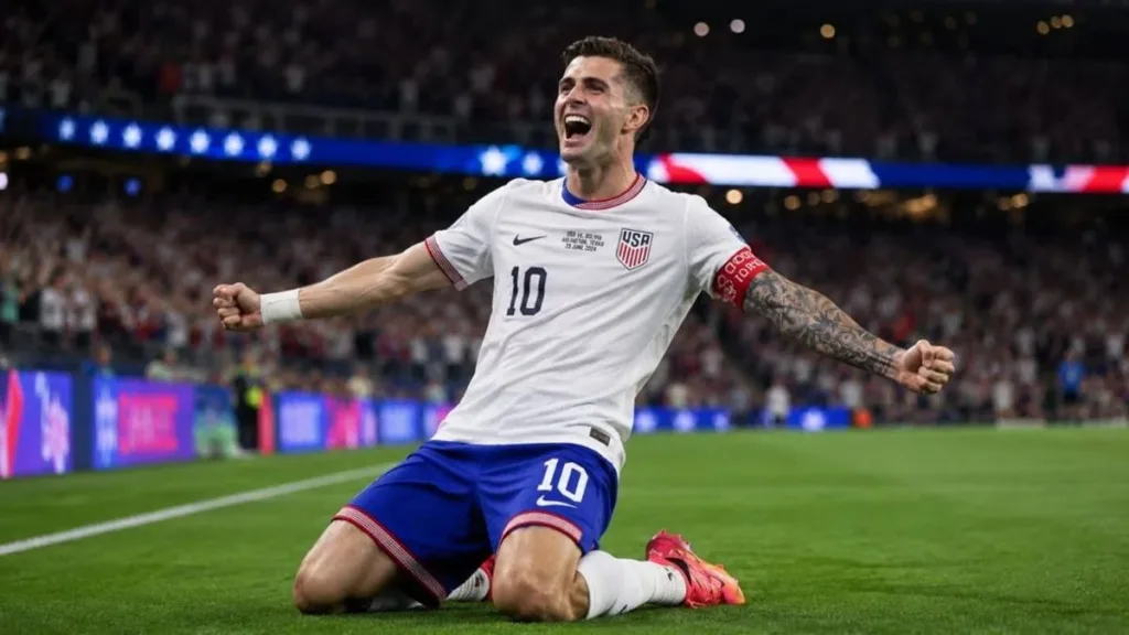 Uma Copa Diferente | Veja Tudo Sobre a Primeira Copa do Mundo com Três Sedes e 48 Seleções 1 Jogador da seleção dos EUA fazendo "carrinho" para comemorar gol, braços abertos e sorriso.