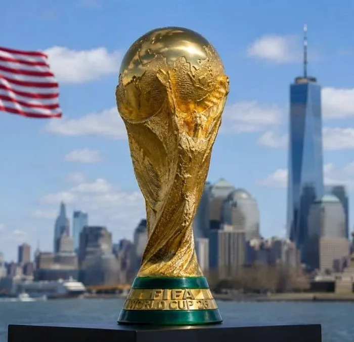 Troféu da copa do mundo de futebol com fundo dos EUA com vista de Nova Iorque, bandeira do país tremulando ao fundo.
