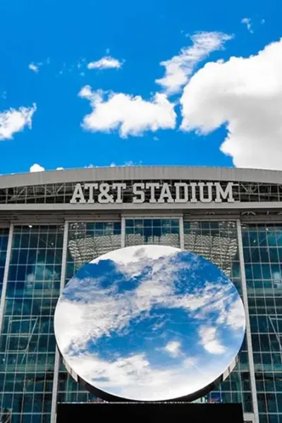 Copa do Mundo 2026 | Os Estádios Que Vão Fazer História Esta é uma vista exterior do AT&T Stadium em Arlington, Texas, com a escultura "Sky Mirror" de Anish Kapoor em destaque.