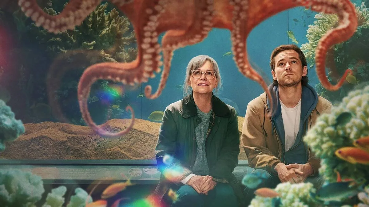 Imagem de divulgação, horizontal, do filme "Criaturas Extraordinariamente Brilhantes". Protagonistas obsevam polvo em aquário com fascínio.