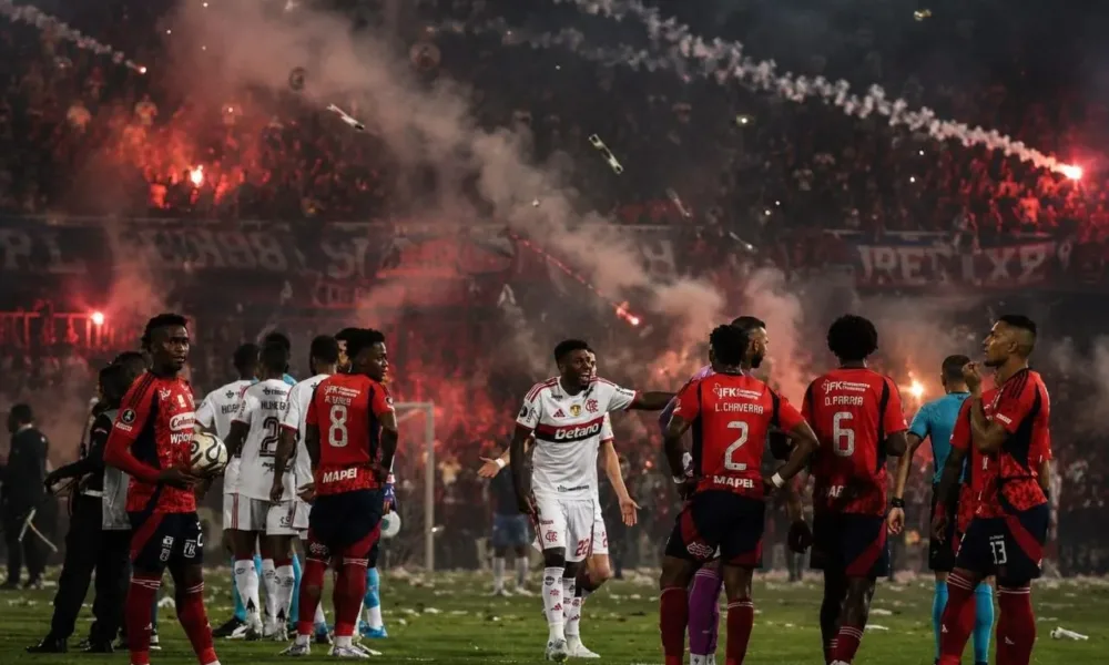 Jogadores do Flamengo e Independiente Medellín em partida durante jogo com confusão da torcida, que levou à punição do time colombiano. Imagem gerada por IA.