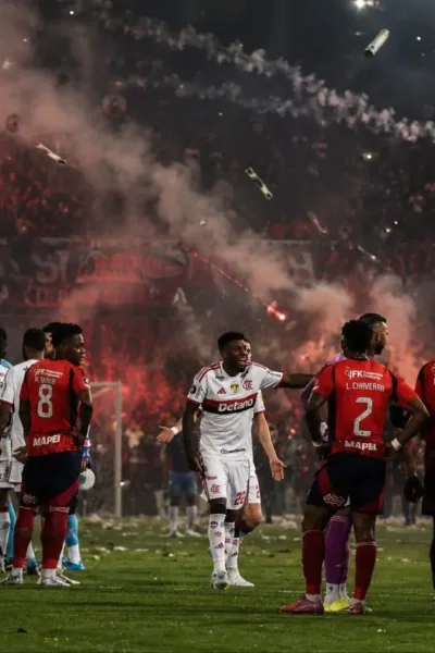 Jogadores do Flamengo e Independiente Medellín em partida durante jogo com confusão da torcida, que levou à punição do time colombiano. Imagem gerada por IA.