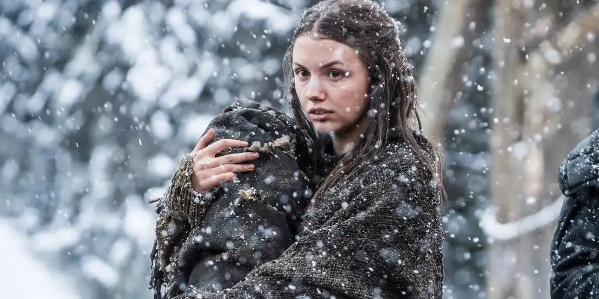 Game of Thrones | Hannah Murray Revela Surto Psicótico Após Envolvimento Com Seita de Bem-estar Hannah Murray no episódio 7 da 5ª temporada de "Game of Thrones" interpretando a personagem Gilly. Neva e ela segura um corpo no braço, como um bebê.