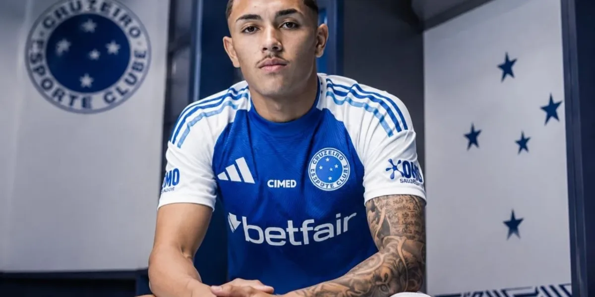 Kauã Moraes, do Cruzeiro, sentado em vestiário com mãos cruzadas e braços sobre os joelhos, expressão neutra. Imagem gerada por IA.
