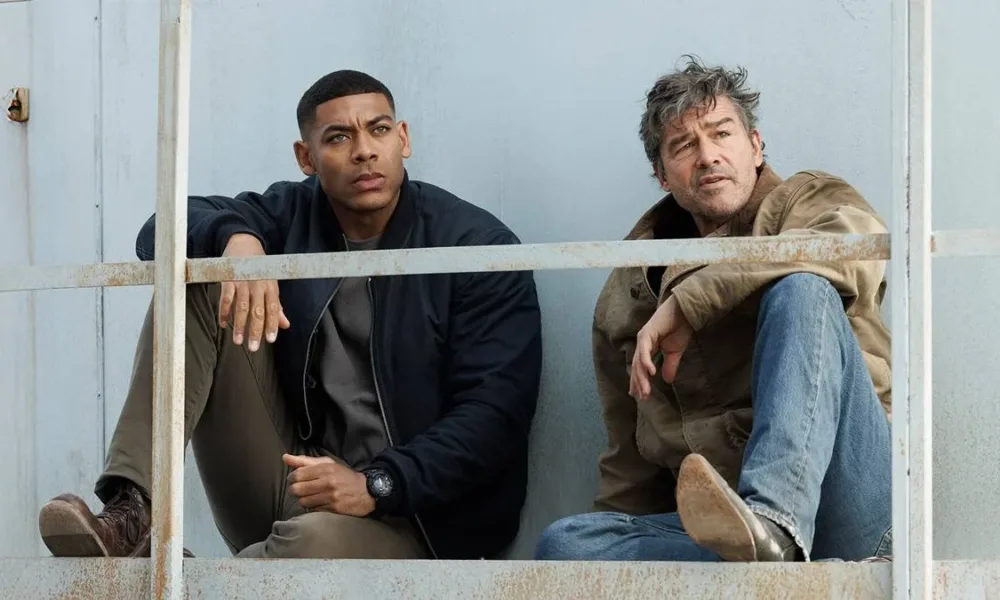 Aaron Pierre (esquerda) e Kyle Chandler (direita) como dois lanternas na nova série adaptada dos quadrinhos da DC sobre os heróis, interpretando John Stewart e Hal Jordan, respectivamente. Ambos estão sentados olhando distante.