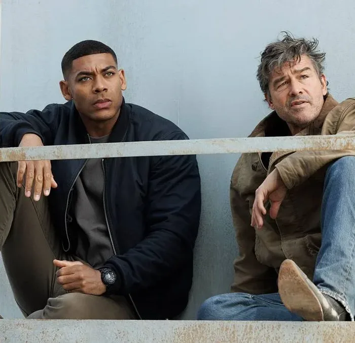Aaron Pierre (esquerda) e Kyle Chandler (direita) como dois lanternas na nova série adaptada dos quadrinhos da DC sobre os heróis, interpretando John Stewart e Hal Jordan, respectivamente. Ambos estão sentados olhando distante.