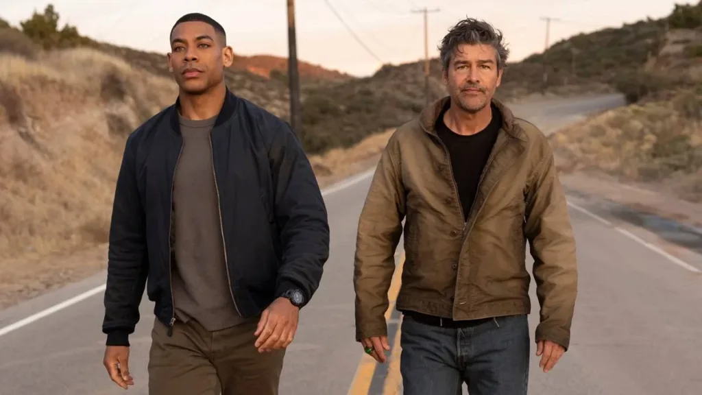 Aaron Pierre (esquerda) e Kyle Chandler (direita) como dois lanternas na nova série adaptada dos quadrinhos da DC sobre os heróis, interpretando John Stewart e Hal Jordan, respectivamente. Ambos estão em pé caminhando em uma estrada em uma paisagem seca.