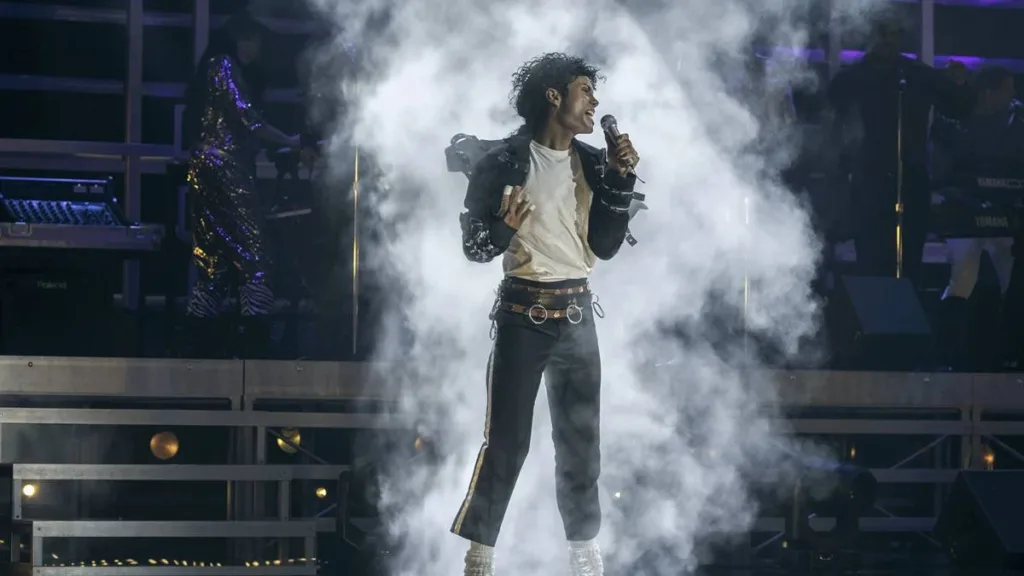 Jaafar Jackson na cinebiografia "Michael", interpretando o tio Michael Jackson. Ele está no palco cheio de gelo seco ao fundo em performance.