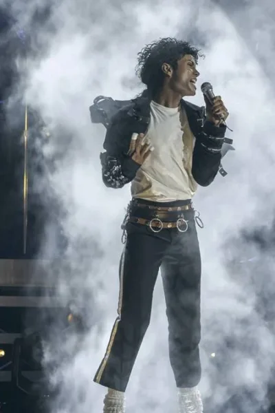 Jaafar Jackson na cinebiografia "Michael", interpretando o tio Michael Jackson. Ele está no palco cheio de gelo seco ao fundo em performance.
