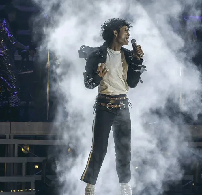 Jaafar Jackson na cinebiografia "Michael", interpretando o tio Michael Jackson. Ele está no palco cheio de gelo seco ao fundo em performance.