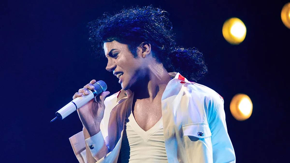 Jaafar Jackson caracterizado como seu tio, Michael Jackson, no filme biográfico "Michael" em performance com trajes brancos.
