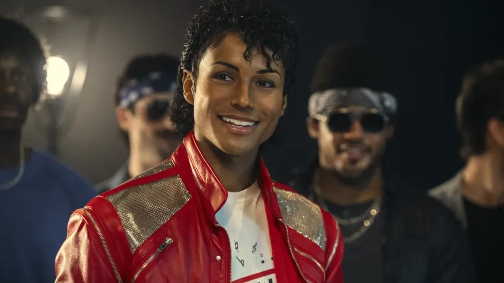 Jaafar Jackson caracterizado como seu tio, Michael Jackson, no filme biográfico "Michael", dançarinos ao fundo.