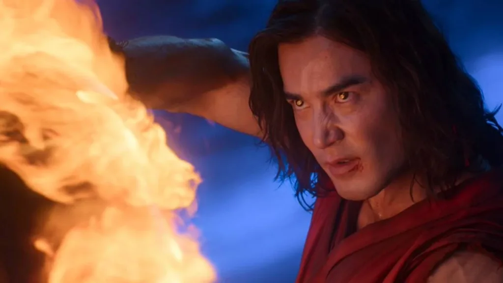 Esta imagem mostra o ator Ludi Lin interpretando o personagem Liu Kang no filme Mortal Kombat II. Personagem está com olhos refletindo as chamas que está para lançar.