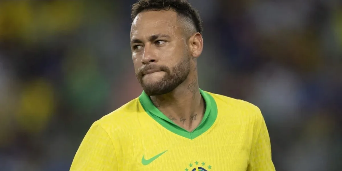Neymar Pode Estar Cada Vez Mais Longe da Copa Após Desgaste Interno na CBF, Diz Jornalista Neymar, rosto virado, lábios para dentro, expressão neutra, durante partida, fundo embaçado de audiência em estado. Ele está com camisa da seleção brasileira. Imagem gerada por IA.