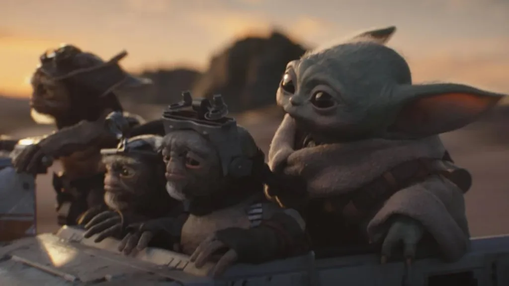 O Mandaloriano e Grogu | Filme Resgata a Essência Clássica de Star Wars nos Cinemas 1 Grogu cercado de outros alienígenas em "O Mandaloriano e Grogu" em um fundo de fim de tarde numa paisagem desértica do filme "Mandaloriano e Grogu".