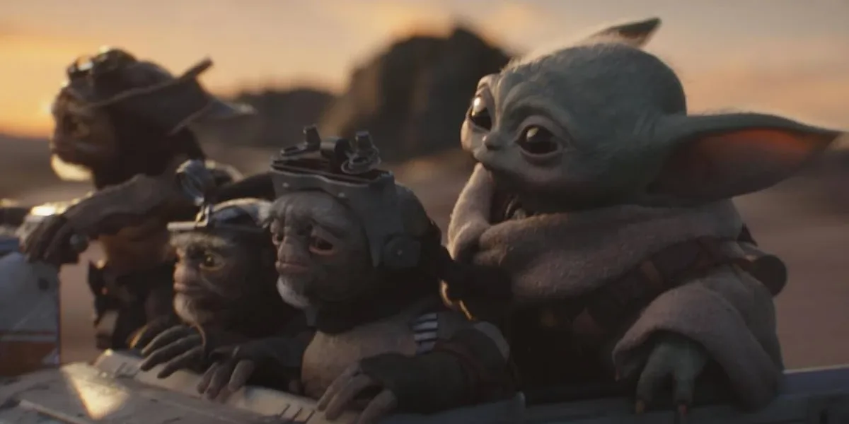O Mandaloriano e Grogu | Filme Estreia Abaixo de Solo e Acende Alerta Para Star Wars nos Cinemas Grogu cercado de outros alienígenas em "O Mandaloriano e Grogu" em um fundo de fim de tarde numa paisagem desértica do filme "Mandaloriano e Grogu".