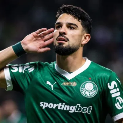 Esta imagem mostra o atacante argentino José Manuel "Flaco" López, que atualmente joga pelo Palmeiras. Ele leva a mão esquerda à orelha. Imagem gerada por IA.