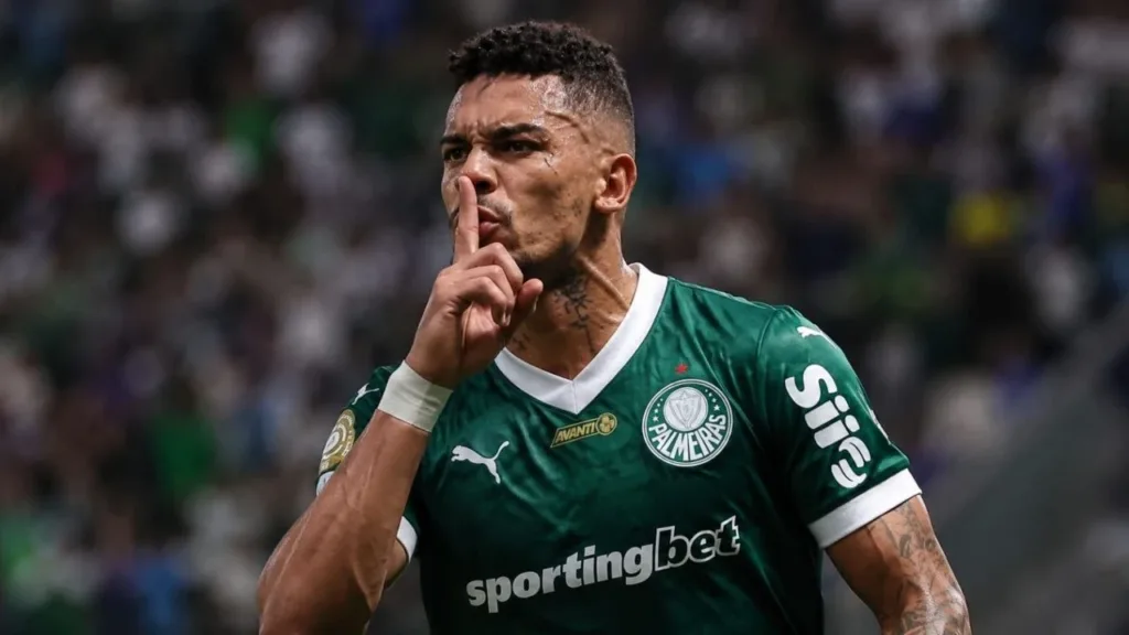 Flamengo Começa o Jogo bem, Carrascal é expulso e time toma um atropelo em um Maracanã lotado 2 Esta imagem mostra Paulinho, jogador de futebol brasileiro, ele leva o indicador ao rosto em sinal pedindo silêncio durante partida. Imagem gerada por IA.