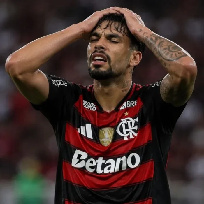 Esta imagem mostra Lucas Paquetá vestindo a camisa do Flamengo. Ele leva as mãos à cabeça em desespero. Imagem gerada por IA.