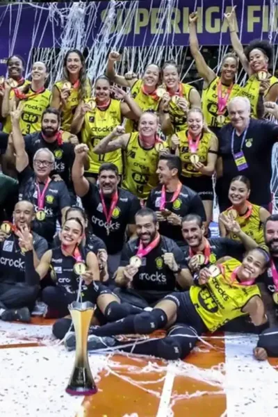 Time do Praia Clube após partida contra o Minas comemorando o campeonato na Superliga Feminina de Voleibol.