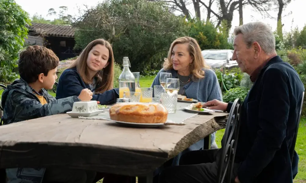 Still do filme "Querendo Ou Não", 2025. Professor em refeição com a família.
