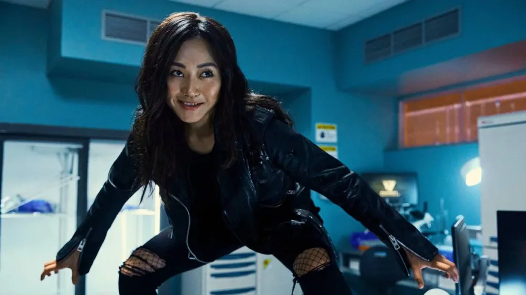 The Boys (5ª Temporada) | Entre Acertos e Excessos, Série Encerra Sua História, Com Desempenho Abaixo do Esperado 3 Karen Fukuhara como Kimiko Miyashiro, sorriso amarelo, equilibrada sobre uma mesa no 8º episódio da 3ª temporada de "The Boys".