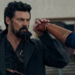 Esta imagem mostra um momento crucial entre Billy Butcher e o Capitão Pátria na temporada final da série The Boys. A cena faz parte do episódio final da 5ª temporada, intitulado "Blood and Bone". O confronto representa o clímax da rivalidade entre os dois personagens principais.