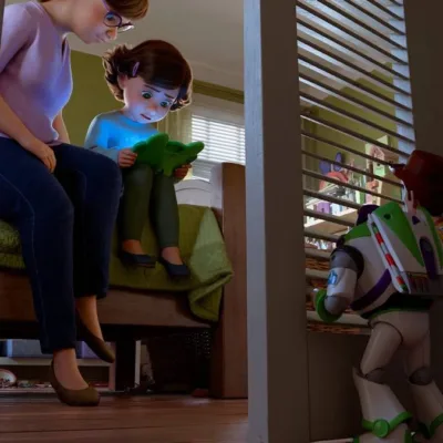 Esta imagem é uma cena oficial do filme Toy Story 5. A trama envolve Woody e Buzz observando Bonnie focada em um novo tablet. Woody e Buzz espiam a garota com a mãe, a menor segurando um tablet.