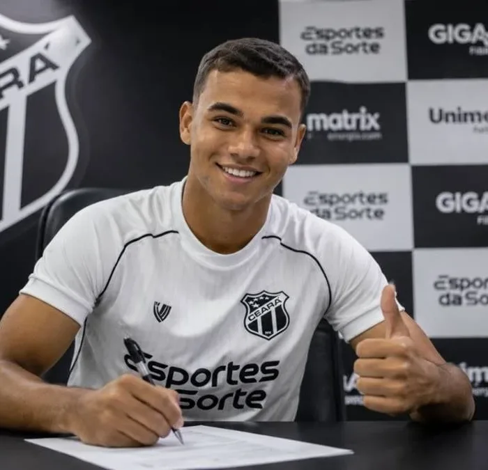 Vinicius Uchella, 20, assinando contrato com o Ceará Sporting Club, com a camisa do time e uma parede de coletiva de imprensa ao fundo. Imagem gerada por IA.