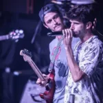 Braza em apresentação no Carioca Club, destaque para membros no palco. Marca d'água do fotógrafo Gui Caielli no canto inferior direito.