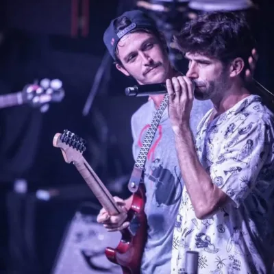 Braza em apresentação no Carioca Club, destaque para membros no palco. Marca d'água do fotógrafo Gui Caielli no canto inferior direito.