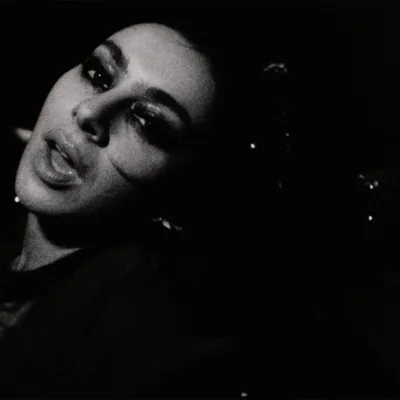 Esta imagem mostra a cantora Charli XCX em um registro em preto e branco para o clipe de sua música "Rock Music".