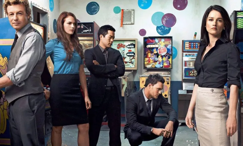 Esta imagem promocional mostra o elenco principal da série de televisão O Mentalista, atuando como seus personagens.