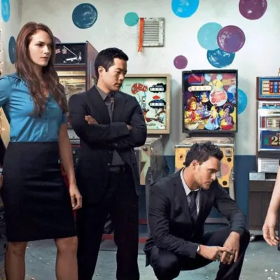 Esta imagem promocional mostra o elenco principal da série de televisão O Mentalista, atuando como seus personagens.