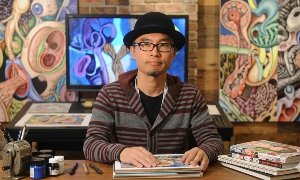Shintaro Kago em estúdio próprio com suas obras ao lado, painel na parede mostra seu estilo artístico bem marcado no surreal. Ele está com chapéu-coco, óculos, expressão neutra. Imagem gerada por IA.